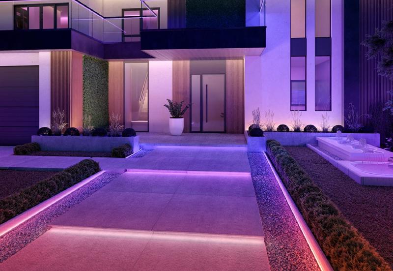 Un bandeau lumineux Philips Hue Neon pour l&rsquo;extérieur, créant une ligne de lumière rose et orange sur la façade d&rsquo;une maison.
