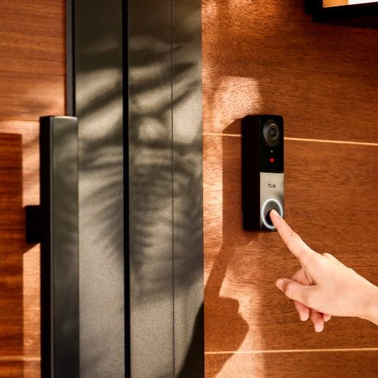 La sonnette vidéo Philips Hue, de couleur blanche, montée sur un mur extérieur.